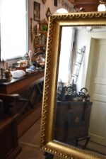 Starožitné nástěnné zrcadlo v zlatém biedermeirovském rámu s listovcem a vejcovcem.