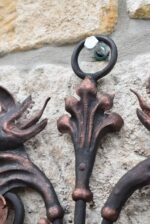 Starožitný ručně kovaný nástěnný věšáček ve tvaru renesanční mříže s hlavičkami dráčků.