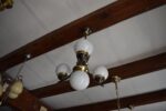 Starožitný lustr ART-DECO z patinované mosazi se třemi skleněnými koulemi a centrální koulí.