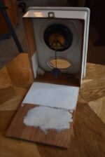 Starožitné prvorepublikové nástěnné kuchyňské hodiny s bílým porcelánovým čílkem a kyvadlem.
