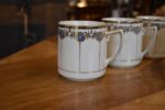Sada 5 ks starožitných secesních porcelánových hrnečků s modrými medailonky a zlatými linkami.