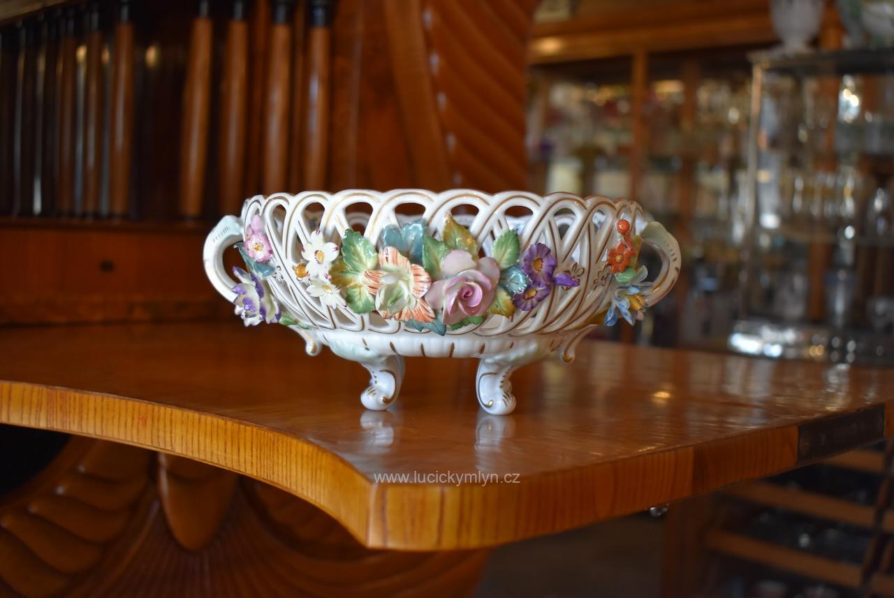 Krásný a nákladně zdobený modře značený vídeňský starožitný nástolec z bílého a plasticky ztvárněného ručně malovaného porcelánu působivě zpodobňujícího tvar proutěného košíčku s drobně modelovanými pestrobarevnými kvítky a lístky - kolem roku 1900 (Kopírovat) Starožitný porcelánový nástolec ve tvaru proutěného košíčku s ručně modelovanými kvítky, Wien.