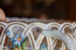 Starožitný porcelánový nástolec ve tvaru proutěného košíčku s ručně modelovanými kvítky, Wien.