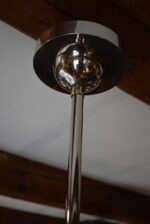 Starožitný funkcionalistický tří-ramenný chromovaný lustr s mléčně narůžovělými skleněnými koulemi.