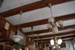 Starožitný funkcionalistický tří-ramenný chromovaný lustr s mléčně narůžovělými skleněnými koulemi.