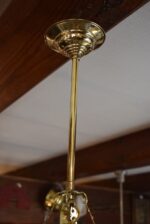 Starožitný secesní ověskový lustr z mosazi s klasicizujícími věnečky a skleněnými ověsky.
