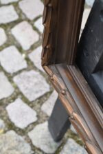 Větší starožitný klasicizující rám z lipového dřeva s měděnou patinací a antickým listovým motivem.
