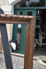 Větší starožitný klasicizující rám z lipového dřeva s měděnou patinací a antickým listovým motivem.