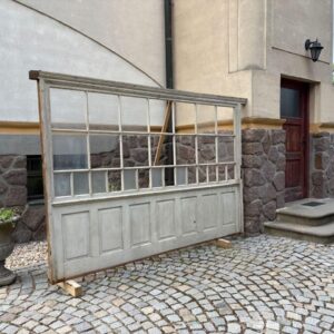Velká starožitná prosklená dělící stěna s kazetami v historizujícím stylu.
