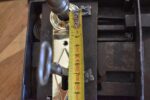 Starožitný klasicistní krabicový dveřní zámek s litinovou klikou a mosazným štítkem.