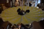 Retro talířový lustr se žlutě lakovaným plasticky strukturovaným skleněným stínidlem ve tvaru geometrického květu.