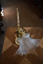 Starožitná secesní mosazná stolní lampa s posuvným ramenem a foukaným stínidlem ve tvaru květu.
