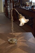 Starožitná secesní mosazná stolní lampa s posuvným ramenem a foukaným stínidlem ve tvaru květu.