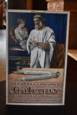 Prvorepubliková reklamní kartonová cedule lékárský teploměr Galenos s postavou starověkého lékaře.