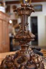 Starožitná stolní lampa z patinované litiny s lvími maskami a broušenou skleněnou koulí.