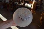 Starožitná stolní lampa z patinované litiny s lvími maskami a broušenou skleněnou koulí.