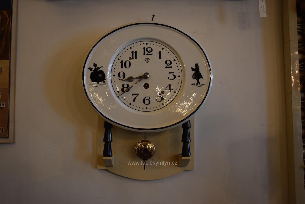 Krásné starožitné kuchyňské hodiny s oválným porcelánovým ciferníkem okrášlené vyhledávaným motivem se stínovými rokokovými postavičkami Starožitné kuchyňské hodiny s oválným porcelánovým ciferníkem a rokokovými stínovými postavičkami.