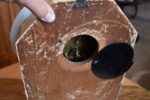 Starožitné kuchyňské hodiny s oválným porcelánovým ciferníkem a rokokovými stínovými postavičkami.