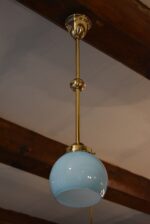 Starožitný mosazný lustřík s modře tónovanou skleněnou koulí.