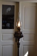Starožitná stojací lampa z niklované litiny, elektrifikovaná z petrolejky, do roku 1900.