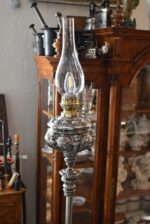 Starožitná stojací lampa z niklované litiny, elektrifikovaná z petrolejky, do roku 1900.