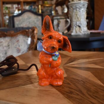 Retro porcelánová stolní lampička ve tvaru červeného pejska s květinou jako noční světlo.