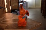 Retro porcelánová stolní lampička ve tvaru červeného pejska s květinou jako noční světlo.