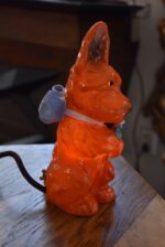 Retro porcelánová stolní lampička ve tvaru červeného pejska s květinou jako noční světlo.