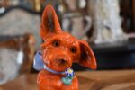 Retro porcelánová stolní lampička ve tvaru červeného pejska s květinou jako noční světlo.