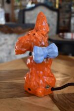 Retro porcelánová stolní lampička ve tvaru červeného pejska s květinou jako noční světlo.