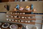 Starožitné diorama historické pekárny s kachlovou pecí a figurkami pekařů.