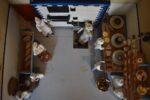 Starožitné diorama historické pekárny s kachlovou pecí a figurkami pekařů.