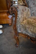 Historyczna sofa z drewna orzechowego w stylu rokokowym, z tapicerką z motywem kwiatów łąkowych.