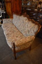 Historyczna sofa z drewna orzechowego w stylu rokokowym, z tapicerką z motywem kwiatów łąkowych.