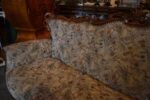 Historyczna sofa z drewna orzechowego w stylu rokokowym, z tapicerką z motywem kwiatów łąkowych.