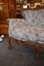 Historyczna sofa z drewna orzechowego w stylu rokokowym, z tapicerką z motywem kwiatów łąkowych.