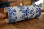 Starožitný porcelánový váleček s cibulákovým motivem a bukovými dřevěnými držadly.