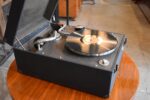 Starožitný kufříkový gramofon Wellington Gramophones s deskou His Master's Voice.