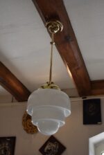 Starožitný lustr ART-DECO ze zlatě leštěné mosazi s opálovým stupňovitě profilovaným stínidlem.
