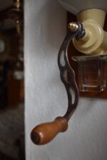 Antyczny młynek do kawy naścienny marki B.O. Garantie Bratři Ouhrabkové z porcelanowym zbiornikiem na kawę.