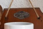 Antyczny młynek do kawy naścienny marki B.O. Garantie Bratři Ouhrabkové z porcelanowym zbiornikiem na kawę.