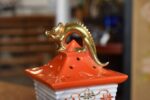 Historická porcelánová lampička ve tvaru lampionu se zlatou figurkou draka.