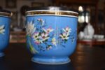 Zabytkowa para porcelanowych doniczek z niebieską powłoką i złotymi zdobieniami.