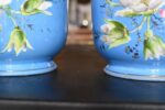 Zabytkowa para porcelanowych doniczek z niebieską powłoką i złotymi zdobieniami.