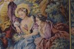 Starožitná žakárová tapiserie Aubusson s pastýřskou scénou a květinovou bordurou.