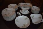 Starožitný jídelní porcelánový servis PULS Ostrov s květinovým dekorem a zlacenými okraji.