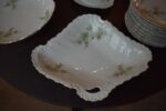 Starožitný jídelní porcelánový servis PULS Ostrov s květinovým dekorem a zlacenými okraji.