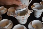 Starožitný porcelánový kávový servis ART-DECO pro 10 osob s květinovým dekorem a zlatou linkou.
