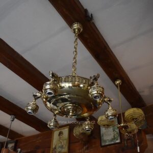 Starožitný secesně klasicizující mosazný lustr s rameny ve tvaru vlčích hlav.