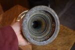 Starožitná mosazná petrolejová lampa ve tvaru poháru se skleněným cylindrem z okolo roku 1910.